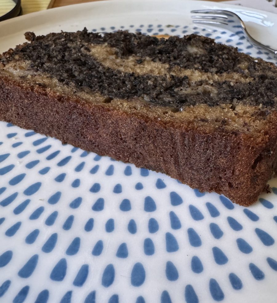 A slice of marbled sesame banana bread on a blue and white plate